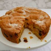 Apple Sponge Cake with a slice removed, on a white plate