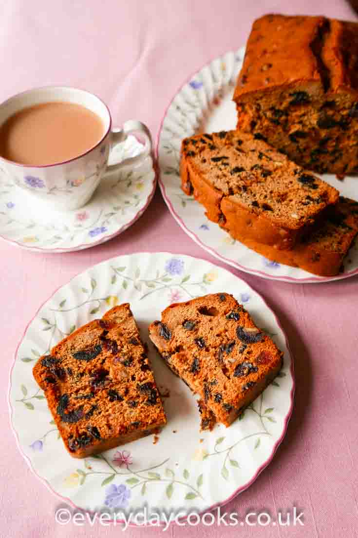 Slices of Everyday Fruit Cake on a plate next to the rest of the cake