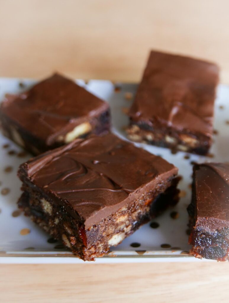 Christmas Chocolate Tiffin slices on a plate. Biscuit, chocolate and fruit soaked in liqueur as the base, coated with chocolate.