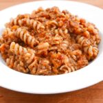 Cowboy dinner - a mince, vegetable and pasta dish with baked beans in a white china bowl.