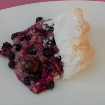 A portion of Black Forest Meringue Pudding on a white plate.
