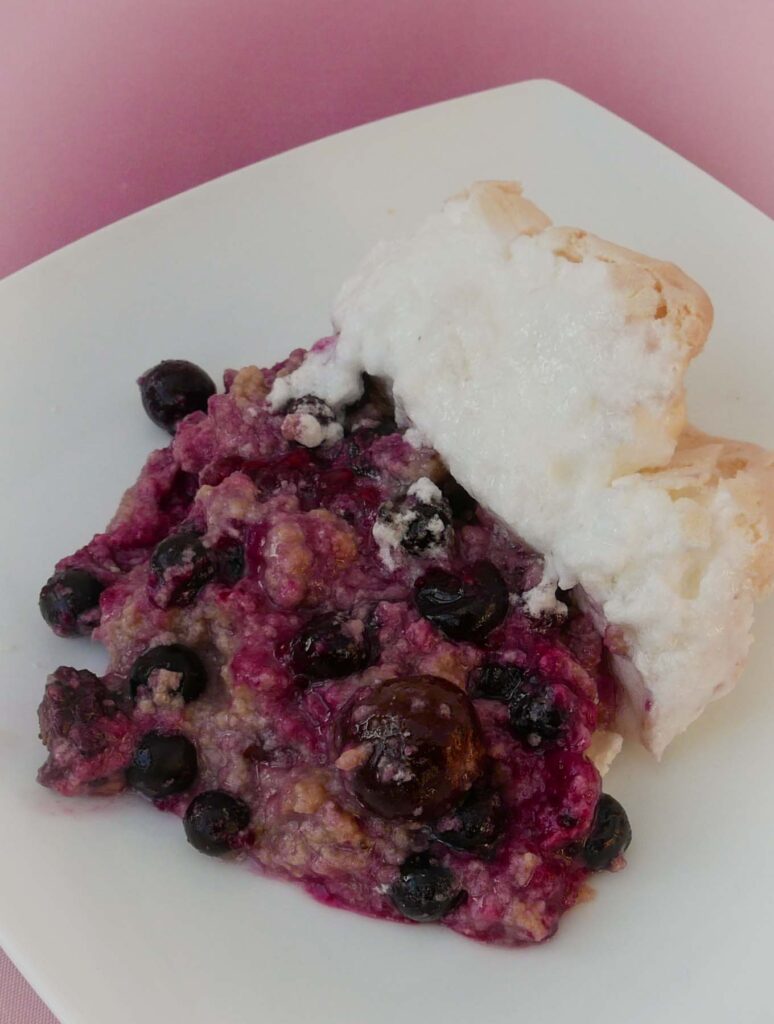 A portion of Black Forest Meringue Pudding on a white plate.