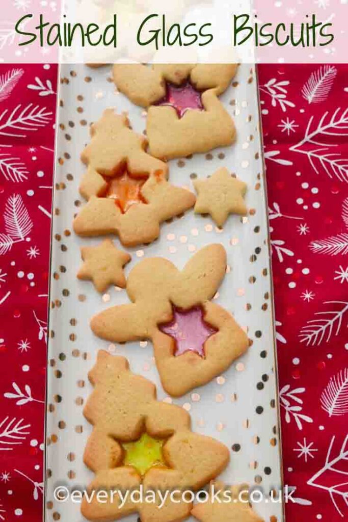 Stained glass biscuits. Angels and Christmas trees with star-shaped windows of orange, red and yellow