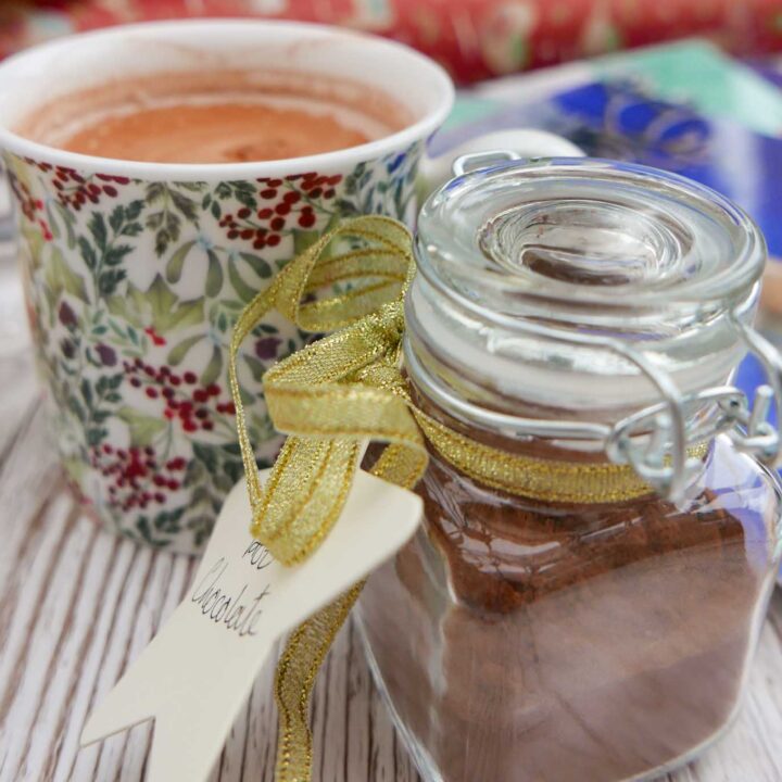 Spiced hot chocolate in a mug with a jar of chocolate mix