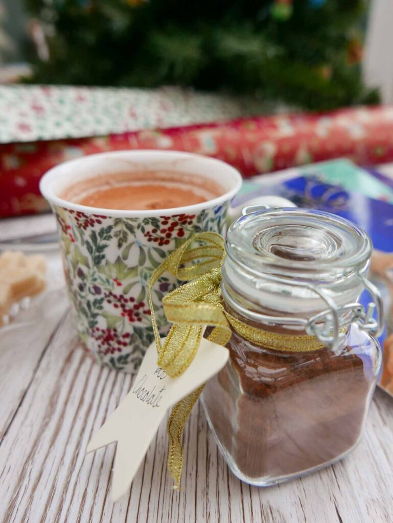 Spiced hot chocolate in a mug with a jar of chocolate mix