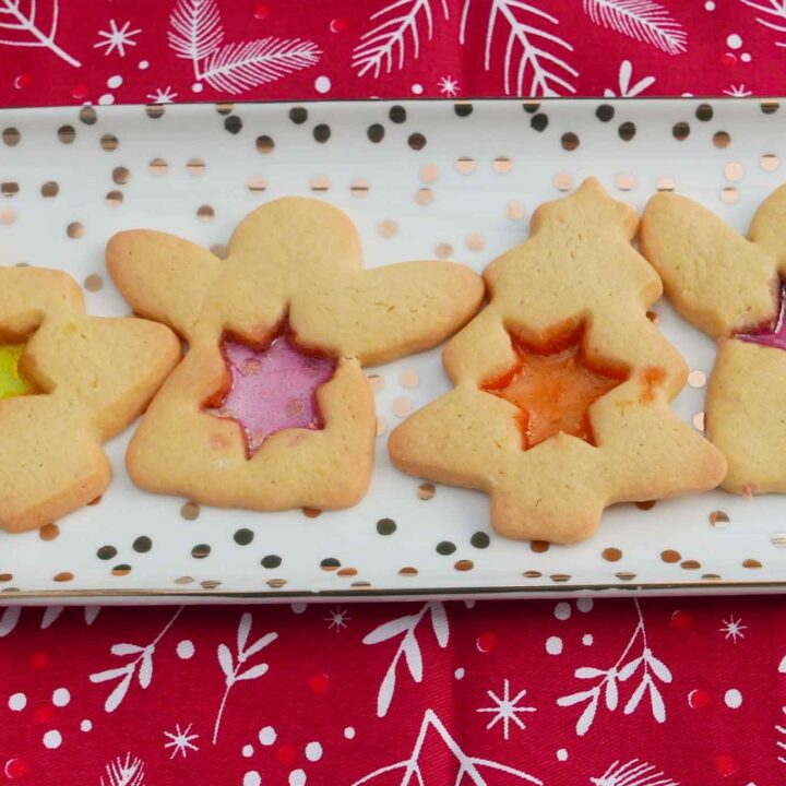 Stained glass biscuits. Angels and Christmas trees with star-shaped windows of orange, red and yellow