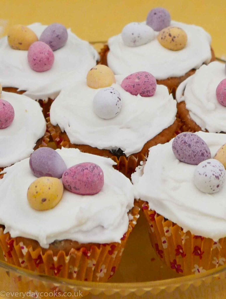 Simnel Cupcakes on a glass dish decorated with icing and chocolate eggs