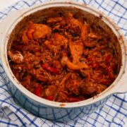 Spanish Chicken and Rice in a blue casserole dish on a blue checked tea towel