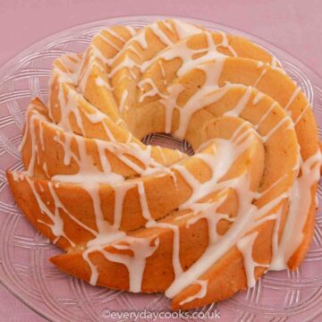 Lemon Bundt Cake with lemon drizzle icing on a glass plate