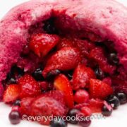 Summer Pudding full of berries with a slice taken.