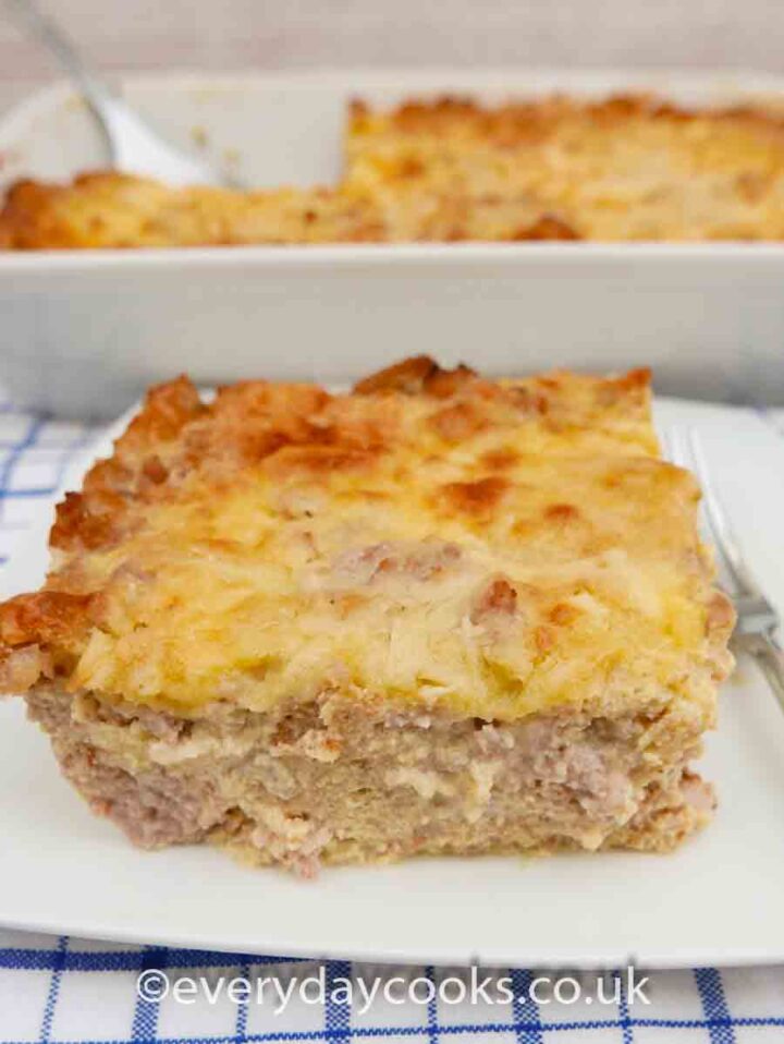 A portion of Breakfast Bake n a white plate with the serving dish in the background