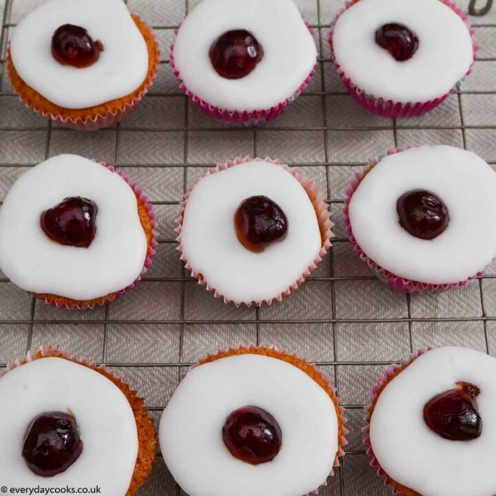 Cherry Bakewell Cupcakes on a wire cooling rack