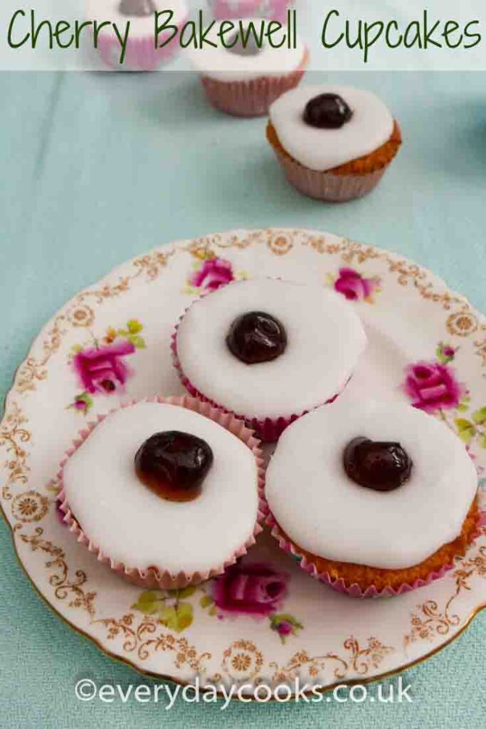 Three Cherry Bakewell Cupcakes on a plate with three in the background