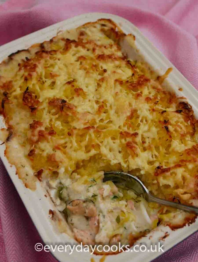 Luxury Fish Pie in a dish with a part of the filling exposed.