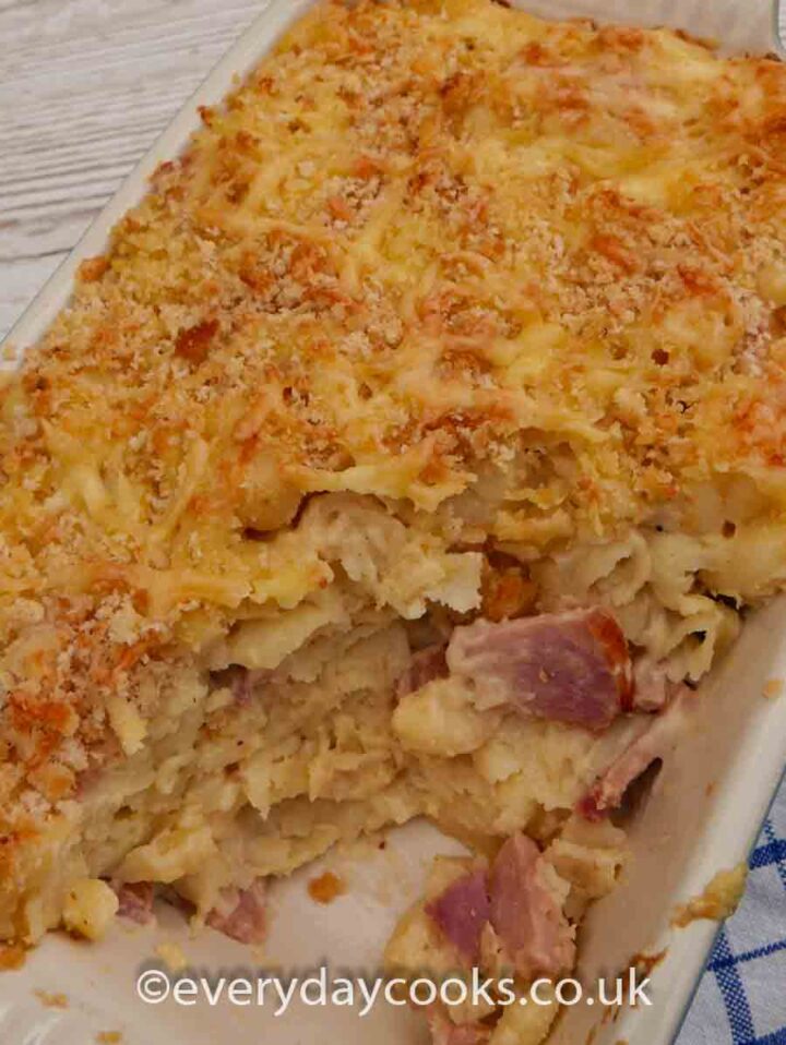 Macaroni Ham and Cheese, with a portion removed, in a gratin dish