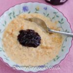 Slow Cooker Rice Pudding in a bowl with raspberry jam.