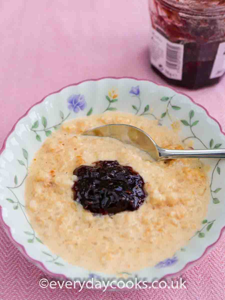 Slow Cooker Rice Pudding in a bowl with raspberry jam.
