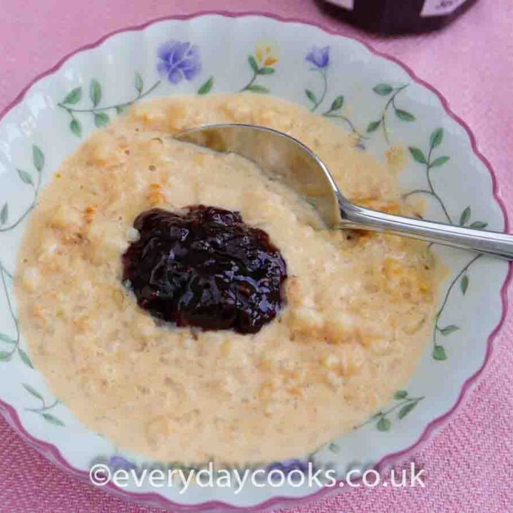 Slow Cooker Rice Pudding in a bowl with raspberry jam.