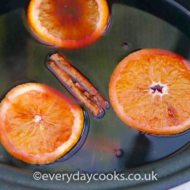 Mulled Wine with whole cinnamon and slices of orange in the Slow Cooker