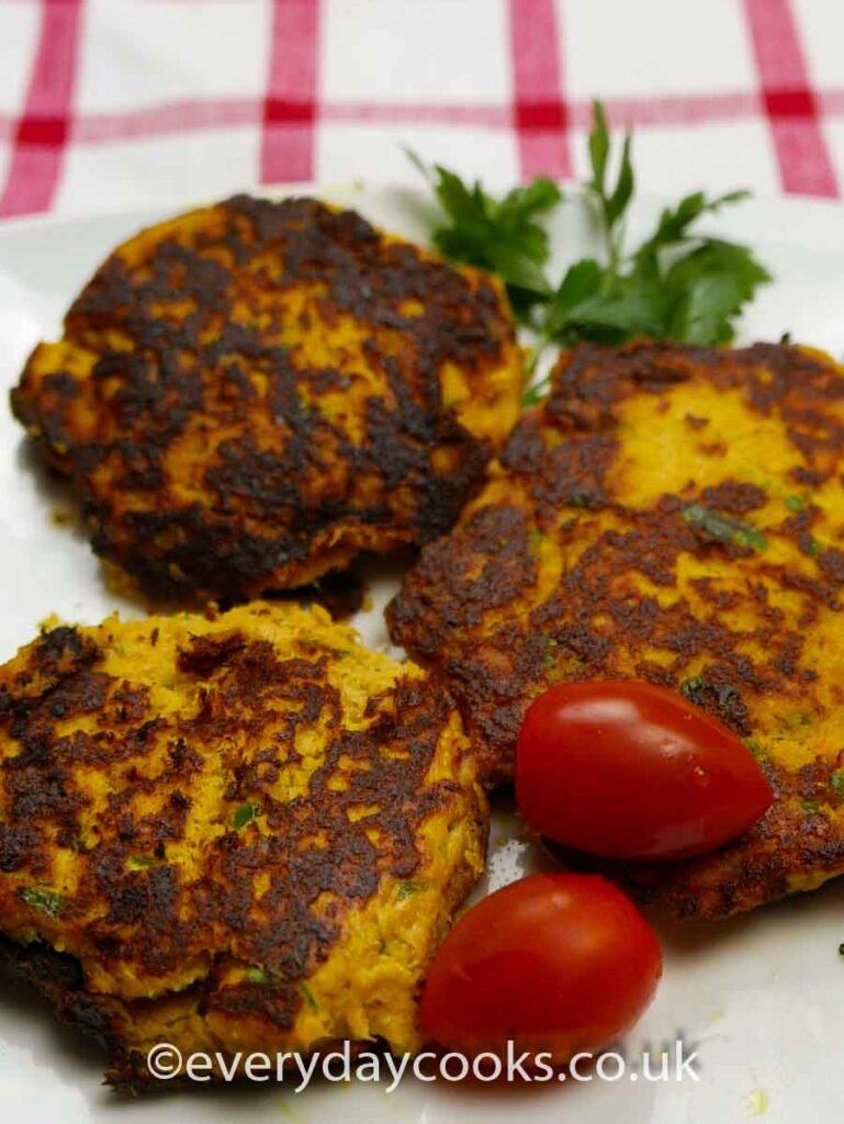 3 Smoked Mackerel Fishcakes on a plate with tomatoes