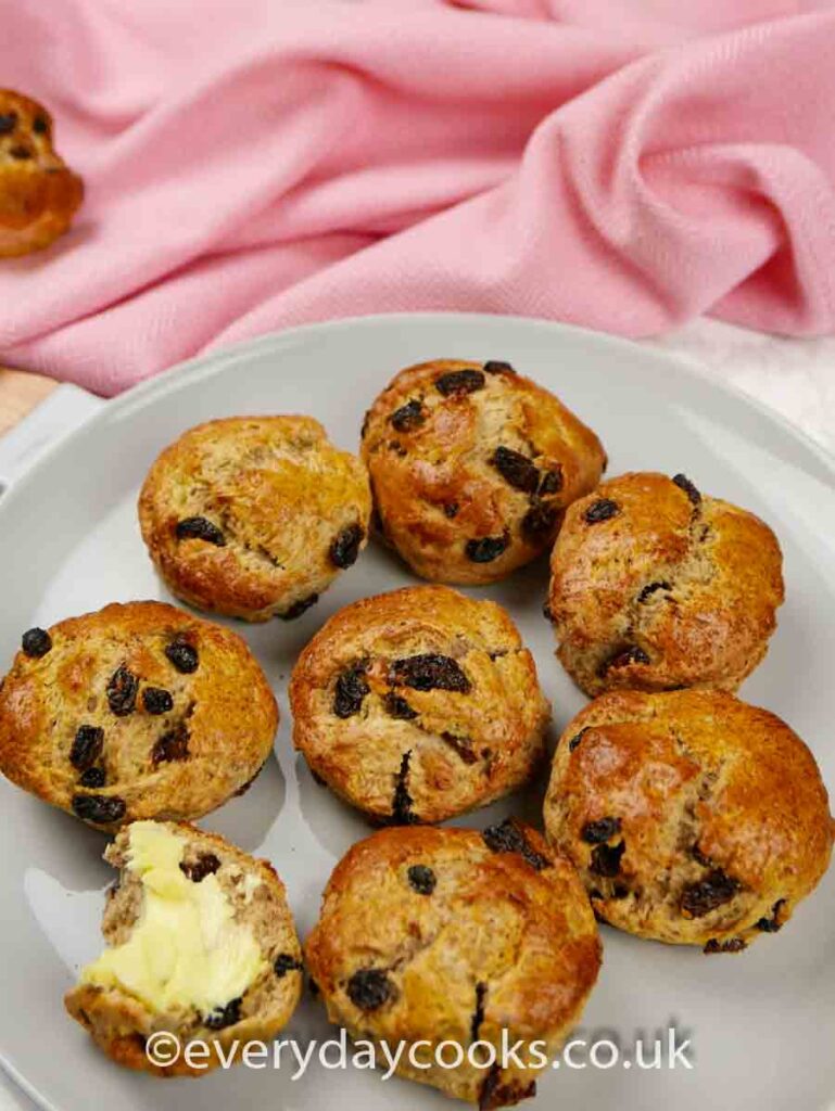 Wholemeal Fruit Scones on a plate. One spread with butter.