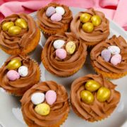 8 Easter Nest Cupcakes full of mini eggs on a grey plate