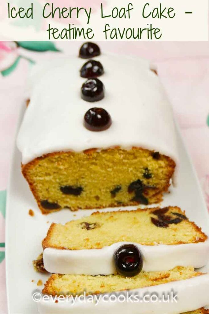 Iced Cherry Cake with a slice cut, on a white plate.