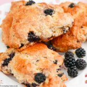 3 Blackberry Scones on a white plate with blackberries.