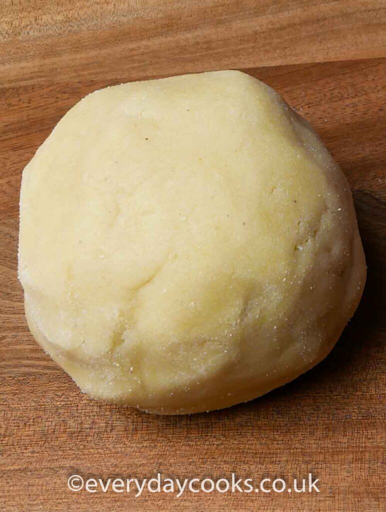 A ball of marzipan on a wooden board