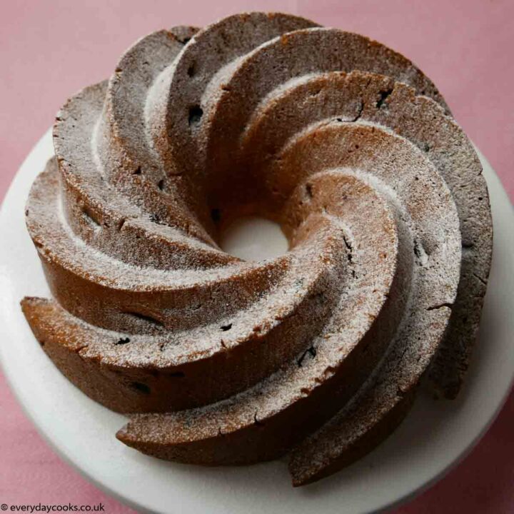 Fruit Bundt Cake with icing sugar on a white plate