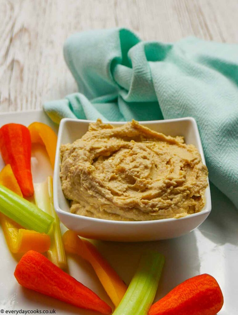 A white dish of Homemade Hummus with raw vegetables