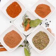 5 Herb and Spice Mixes in small white bowls on a white plate