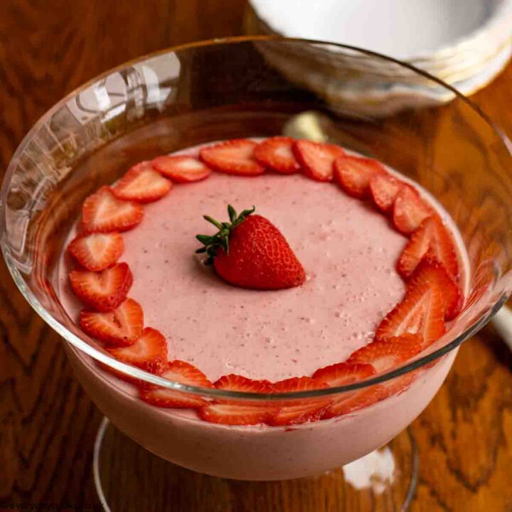 Easy Strawberry Mousse decorated with strawberry slices, in a glass bowl on a wooden table
