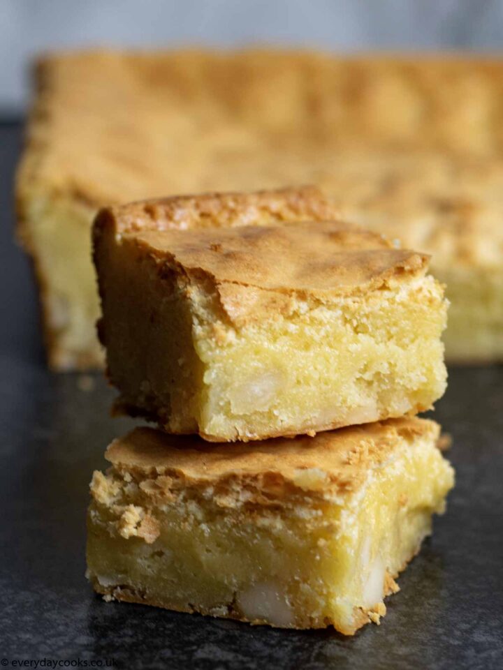 Stack of 2 White Chocolate Brownies in front of the rest of the cake