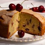 Fresh Cherry Cake, with a slice removed, on a patterned plate