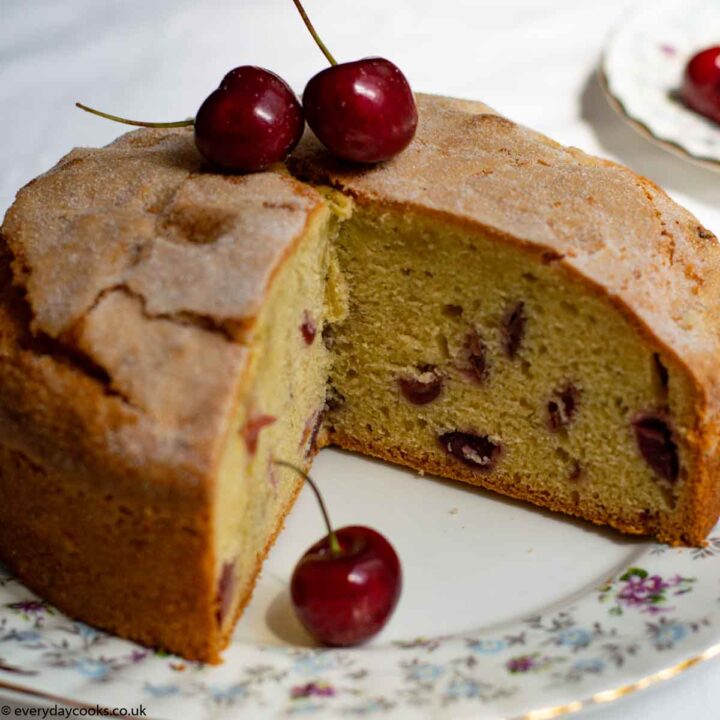 Fresh Cherry Cake, with a slice removed, on a patterned plate