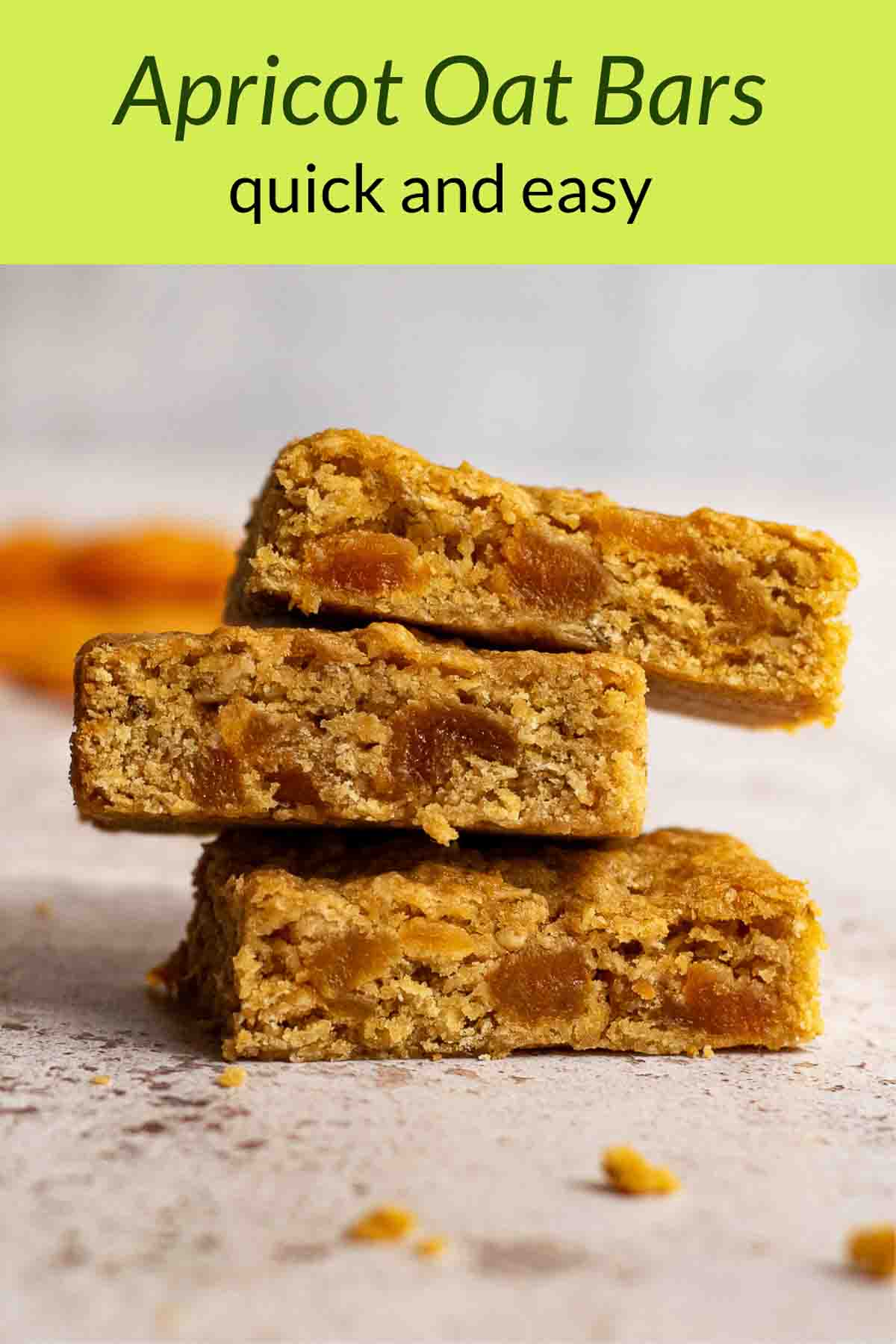 Stack of apricot oat bars with dried apricots in the background