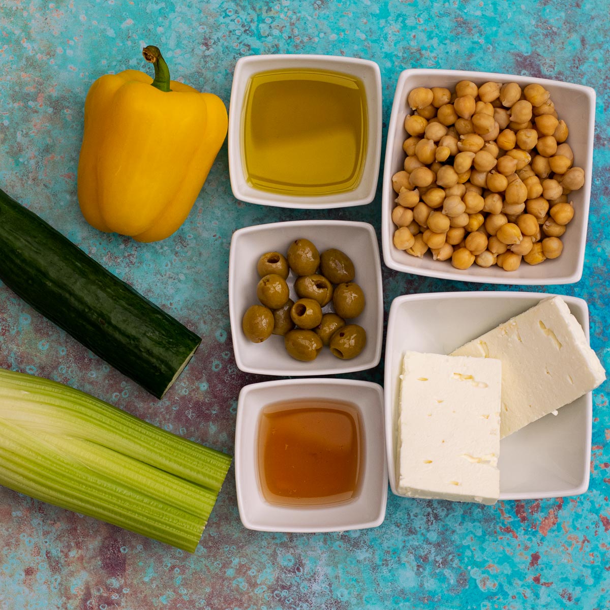 Ingredients for Feta Chickpea Salad on a blue background